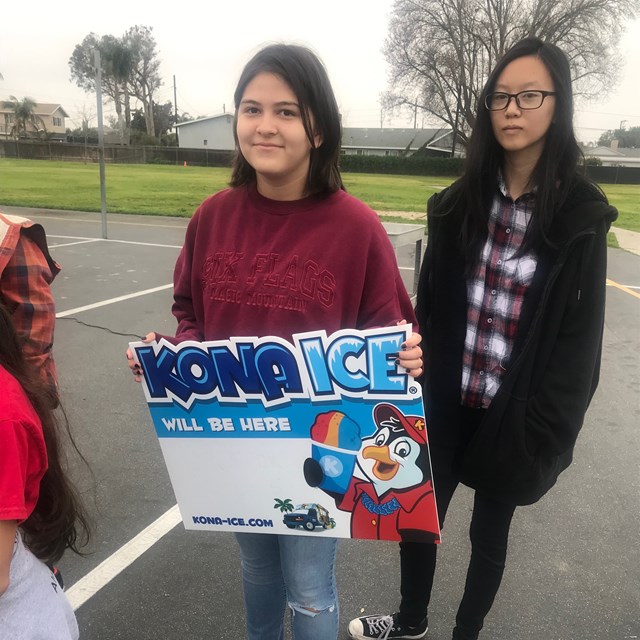 Student holding a Kona Ice sign.