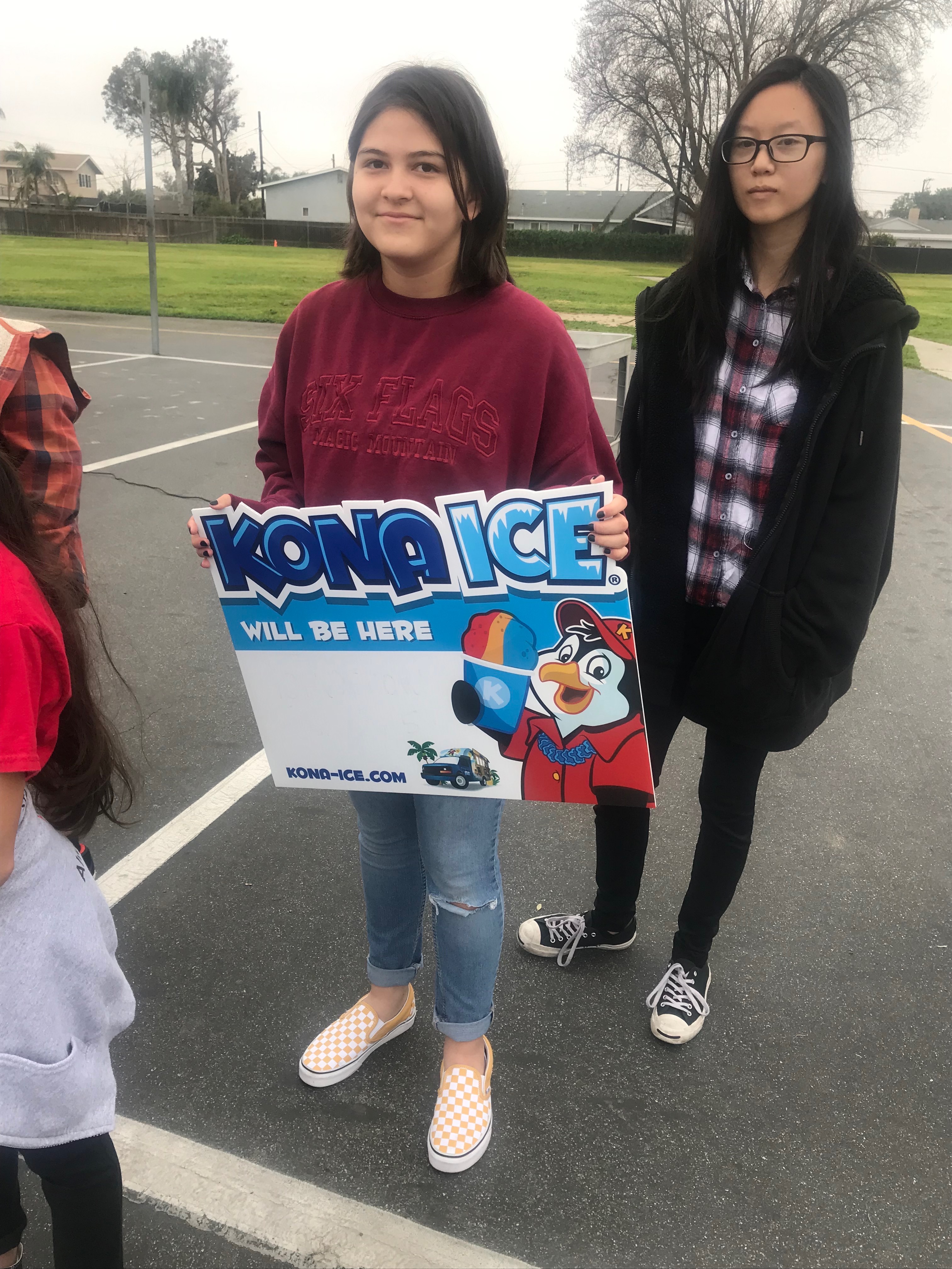 Student holding a Kona Ice sign.